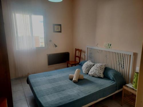 瓦伦西亚Cozy Private Room的一间卧室配有一张带蓝色毯子的床和一台电视。