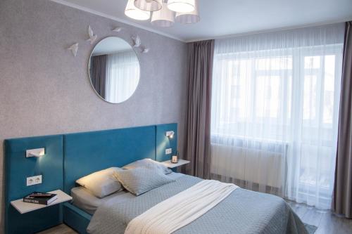 哈尔科夫Аппартаменты Металлист посуточно VIP的一间卧室配有蓝色的床和镜子