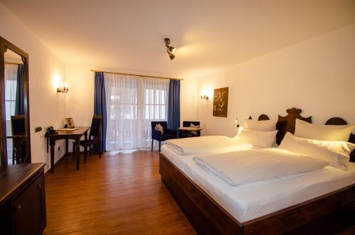 奥巴拉马高s`Wirtshaus Hotel & Restaurant的一间卧室配有一张床、一张桌子和一张桌子