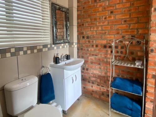 CerillioRuby Granatum的浴室设有白色卫生间和砖墙