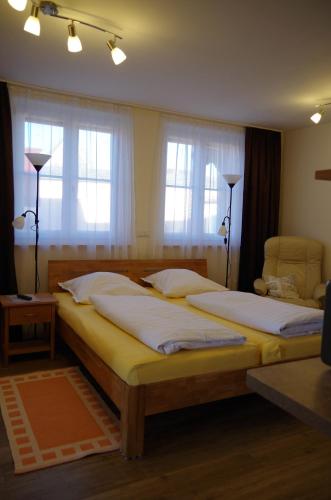 Kirchröttenbach弗莱希曼公寓的一间卧室设有两张床和两个窗户。