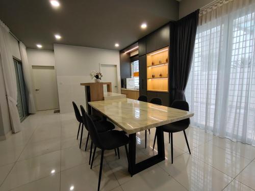 加影Cozy House in Kajang的一间带桌子和黑色椅子的用餐室