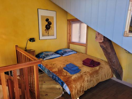 奥瓦伦纳茨Charmant chalet familial ancien的卧室配有一张床铺,位于一个黄色墙壁的房间