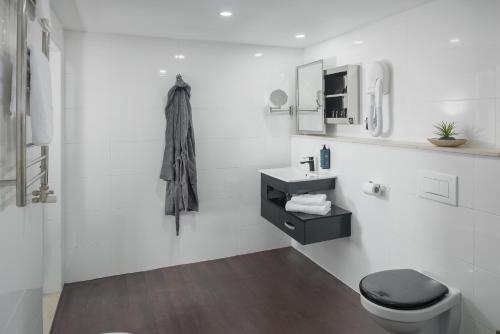 波尔托罗托米酒店的白色的浴室设有卫生间和水槽。