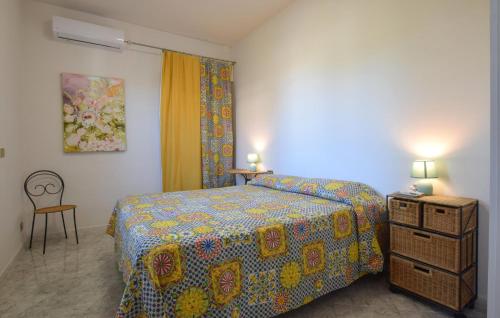 Portella di MareAwesome Apartment In Portella Di Mare With Wifi的一间卧室配有一张床和一个带两盏灯的梳妆台。