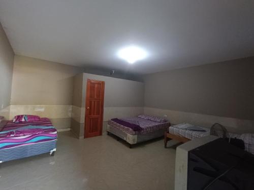 JinotegaHotel Sleep Inn Brumas的一间卧室设有两张床,天花板上拥有灯光
