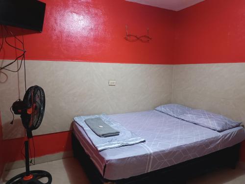 JinotegaHotel Sleep Inn Brumas的一间带一张床和风扇的小卧室