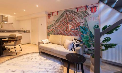 豪达Hofje van Sint Jan的客厅配有沙发和墙上的绘画