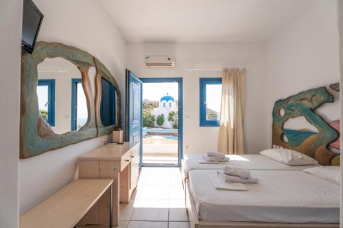 伊奥斯乔拉Fanari Art的一间卧室配有两张床和镜子