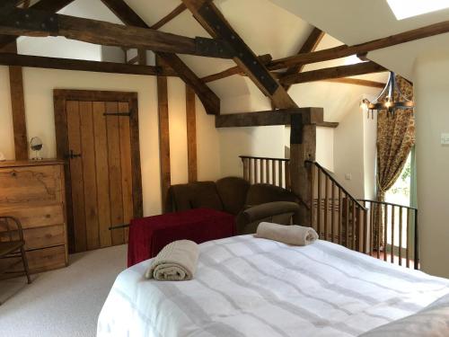 ExfordLuxury Exmoor Barn conversion with Sauna的卧室配有白色的床和椅子