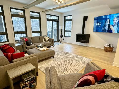 蒙特朗布朗Tremblant Luxe 3BR Pet-friendly, Entertainment!的带沙发和平面电视的客厅