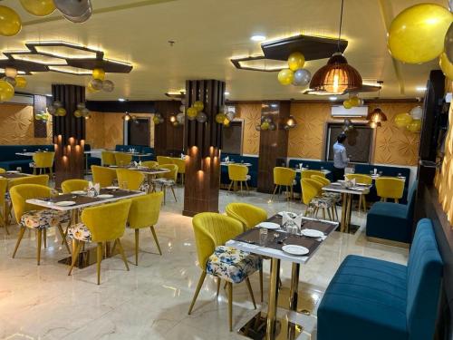 AurangābādHOTEL IMPERIAL的用餐室配有桌子和黄色椅子