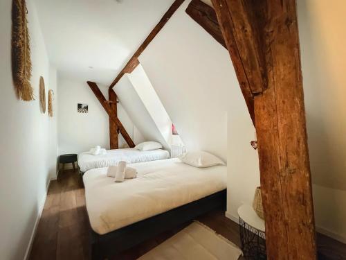 凯泽贝尔Le Gite du Kaiser的阁楼间设有2张床和木梁。