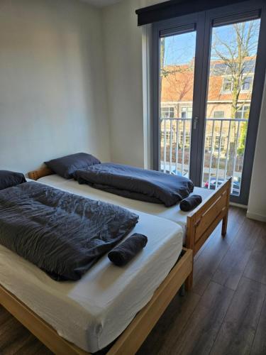 多德雷赫特Residence Dordrecht - 10 persons的带大窗户的客房内的两张床