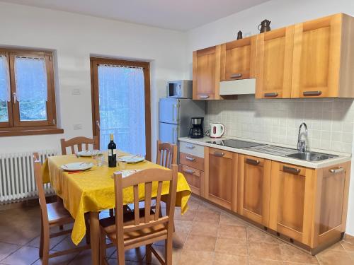 德利纳马索加特姆公寓的厨房配有一张带黄桌布的桌子