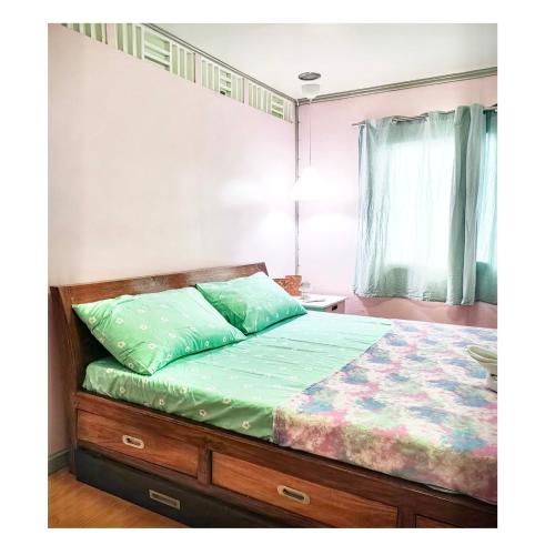 公主港Fely's transient house的一间卧室配有一张双层床和绿色的被子
