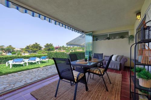 米哈斯科斯塔La Cala gorgeous 2 bedroom apartment with stunning gardens, pools and sea views的天井配有桌椅和沙发。