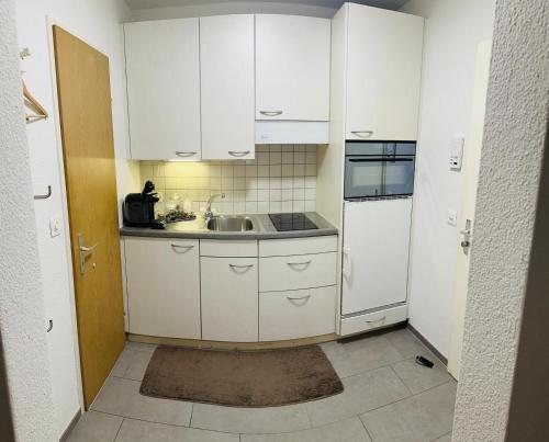 卢塞恩Casa Carvalho的小厨房配有白色橱柜和水槽