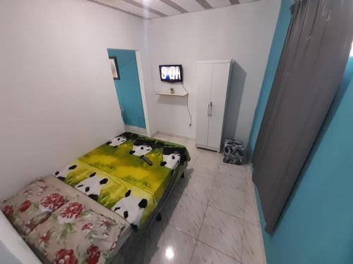 伊塔博拉伊Hospedagem Suites Itaboraí的一间卧室,卧室内有一张床,上面有牛