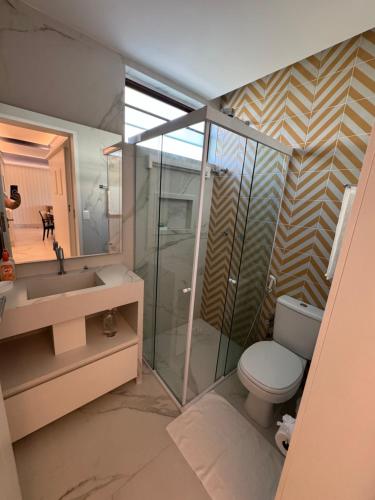 普拉亚多斯卡内罗斯Flat+deck ao lado da igrejinha的一间带卫生间、水槽和镜子的浴室