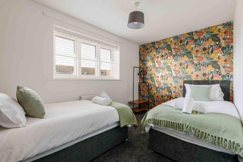 伯恩茅斯2 bedroom House-Driveway - Bournemouth Hospital - Long Stay Discounts - Lima Apartments Ltd的一间卧室设有两张床和花卉壁纸