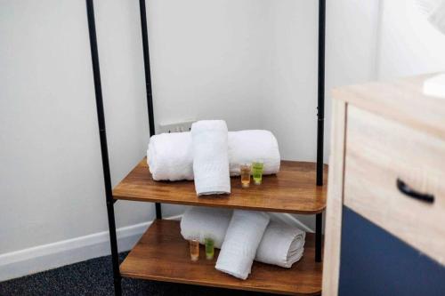 伯恩茅斯2 bedroom House-Driveway - Bournemouth Hospital - Long Stay Discounts - Lima Apartments Ltd的浴室架子上的毛巾堆