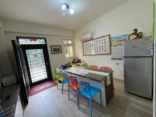 金宁乡八八古藝悅禾民宿的厨房配有冰箱和色彩缤纷的凳子