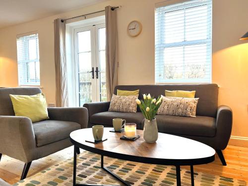 赛伦塞斯特Cosy Cotswold Home - Jacobs Cottage的带沙发和咖啡桌的客厅