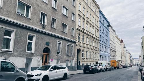 维也纳SpaceOne Vienna A2 - Shared Apartment的一条城市街道,汽车停在大楼旁边