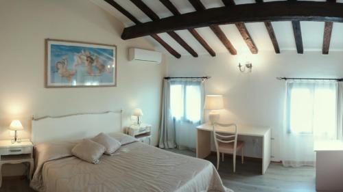 曼托瓦奇塔代拉B＆B别墅酒店的卧室配有一张床和一张桌子及椅子