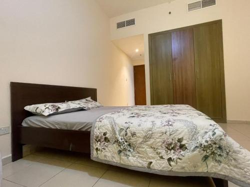 阿吉曼Holiday Home Master bed room in Ajman city UAE的一间卧室配有一张床和一个木制橱柜
