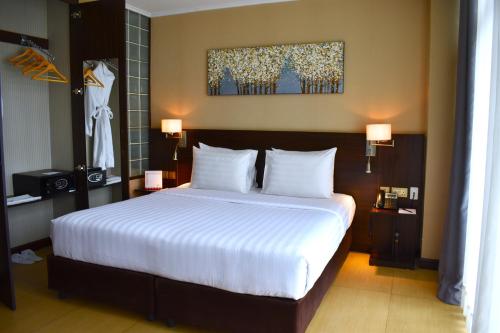 内罗毕Swiss-Belinn Nairobi的一间卧室配有一张带白色床单的大床