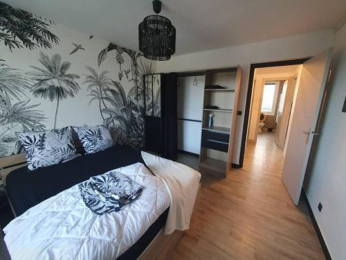 瑟堡Charmant appartement avec vue mer的一间卧室配有白色床单和植物床
