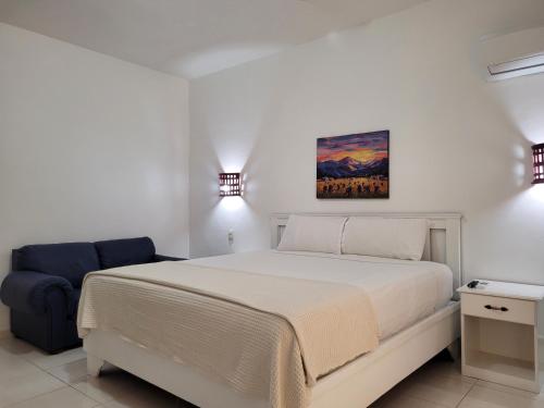 圣多明各Drake Bolivar Santo Domingo的白色卧室配有床和蓝椅