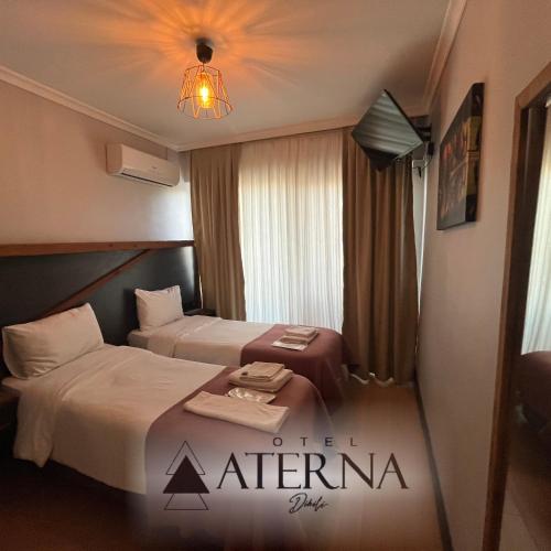 迪基利ATERNA HOTEL的酒店客房设有两张床和吊灯。