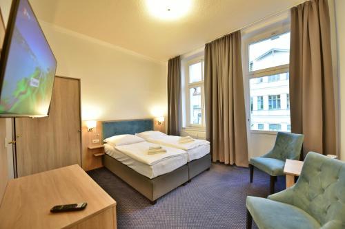 赛巴特班森Hotel Meereseck的一间酒店客房,配有一张床和一台电视