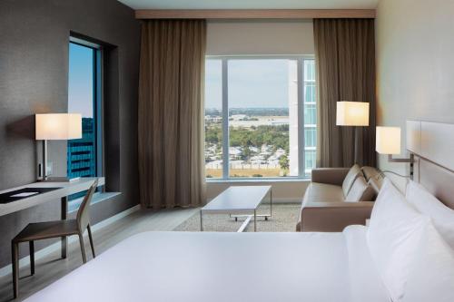 达尼亚滩AC Hotel by Marriott Fort Lauderdale Airport的酒店客房设有一张大床和一张书桌。
