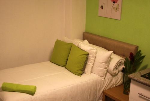 危地马拉Super Precio的客房内的沙发配有绿色和白色枕头