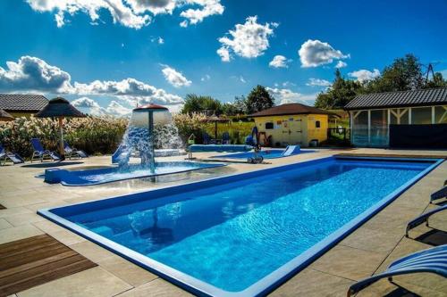 尤斯托尼莫斯基Holiday resort with Pool Whirlpool Sauna Ustronie Morskie的庭院内带喷泉的大型游泳池
