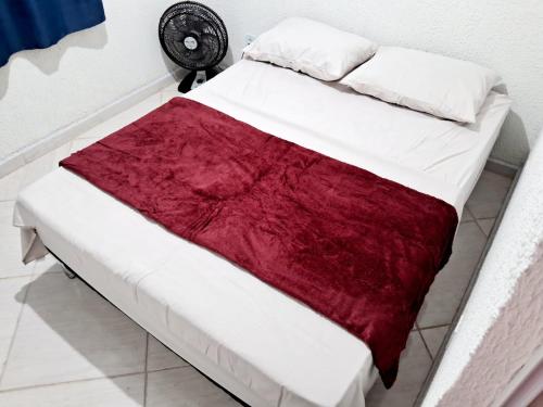 萨夸雷马Mini Casa Aconchegante的床上有红白毯子