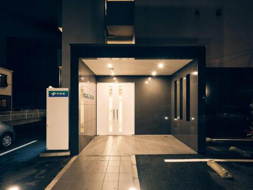 熊本intro vetta 1002 Free Private sauna的大楼入口,带灯的白色门