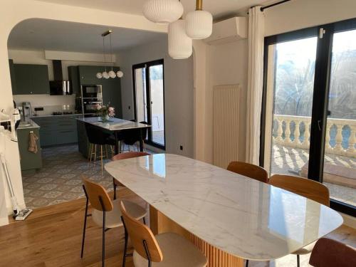 迈松阿尔福Maison 160m2 à 15 min de PARIS/accord arena bercy的厨房以及带白色桌椅的用餐室。