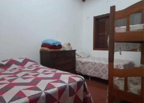 圣加布里埃尔Pousada Claudia e Juliano的一间卧室配有一张床、一个梳妆台和一张双层床。