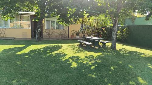 蒙得维的亚Casa Independiente en Punta Gorda的院子里的野餐桌,有树