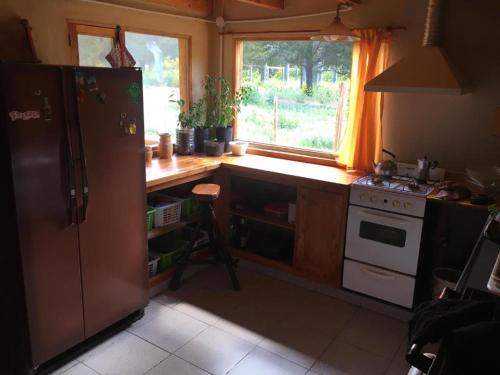 埃普延Carelhue的厨房配有冰箱和炉灶,设有窗户。