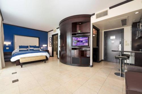 迈阿密海滩Stunning Getaway with Private Outdoor Roman Tub的一间卧室配有一张床和一台平面电视