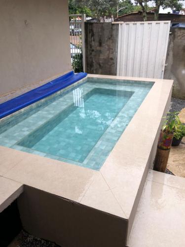 戈亚斯州上帕莱索Reges Hostel的一座房子内的游泳池,铺有瓷砖地板