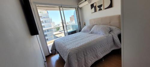 蒙得维的亚Punta Carretas, Garaje, Piscina, Gimnasio的一间卧室设有一张床和一个大窗户