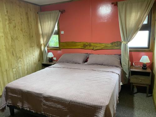 Teodoro SchmidtHostal Rama Fueguina的一间卧室设有一张带红色墙壁的大床