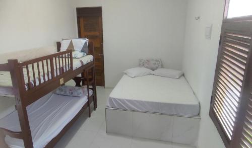 若昂佩索阿Hostel Summer Praia do Sol的客房设有两张床和一张双层床。